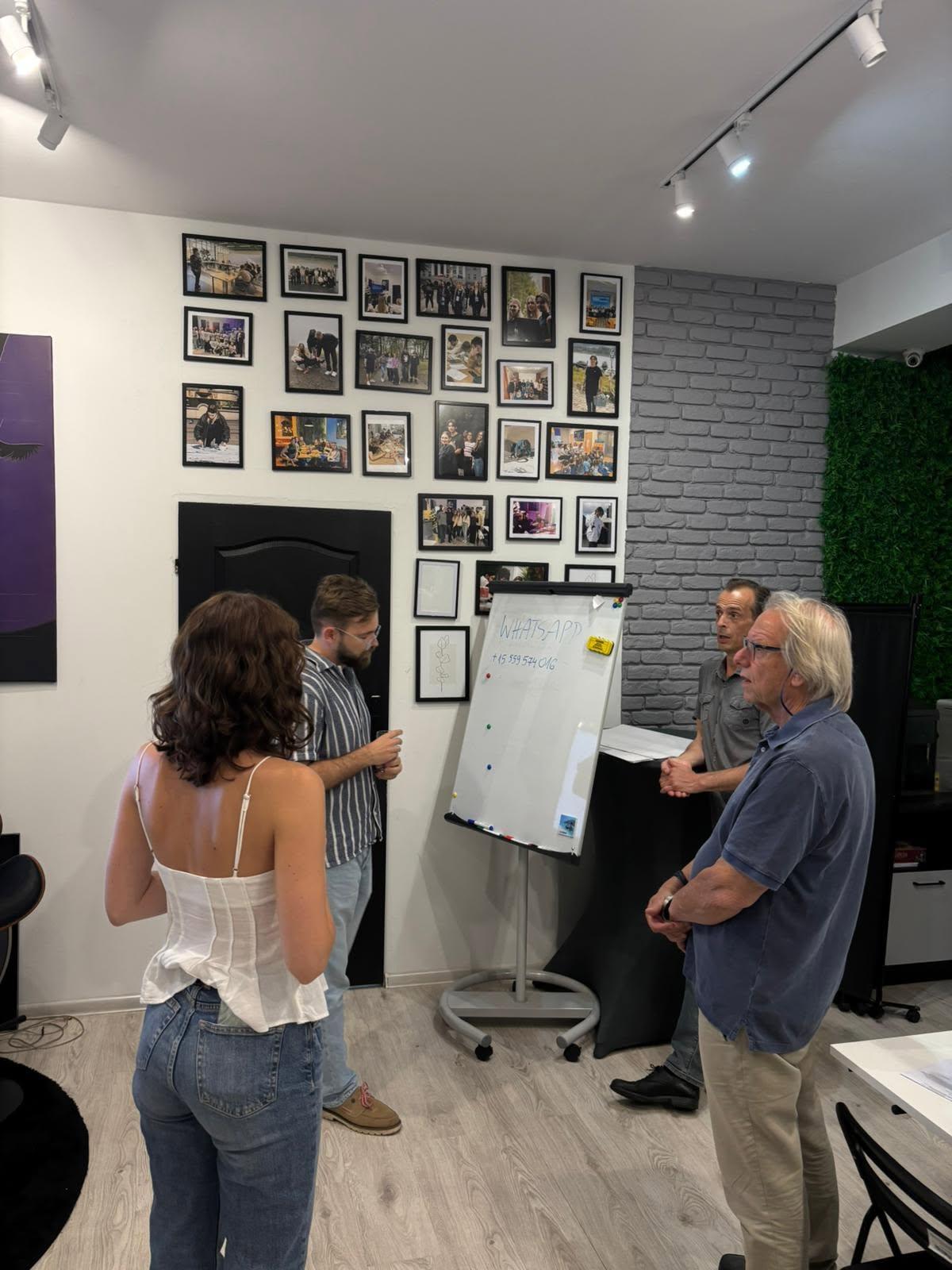 Four people holding a working discussion by a flip chart