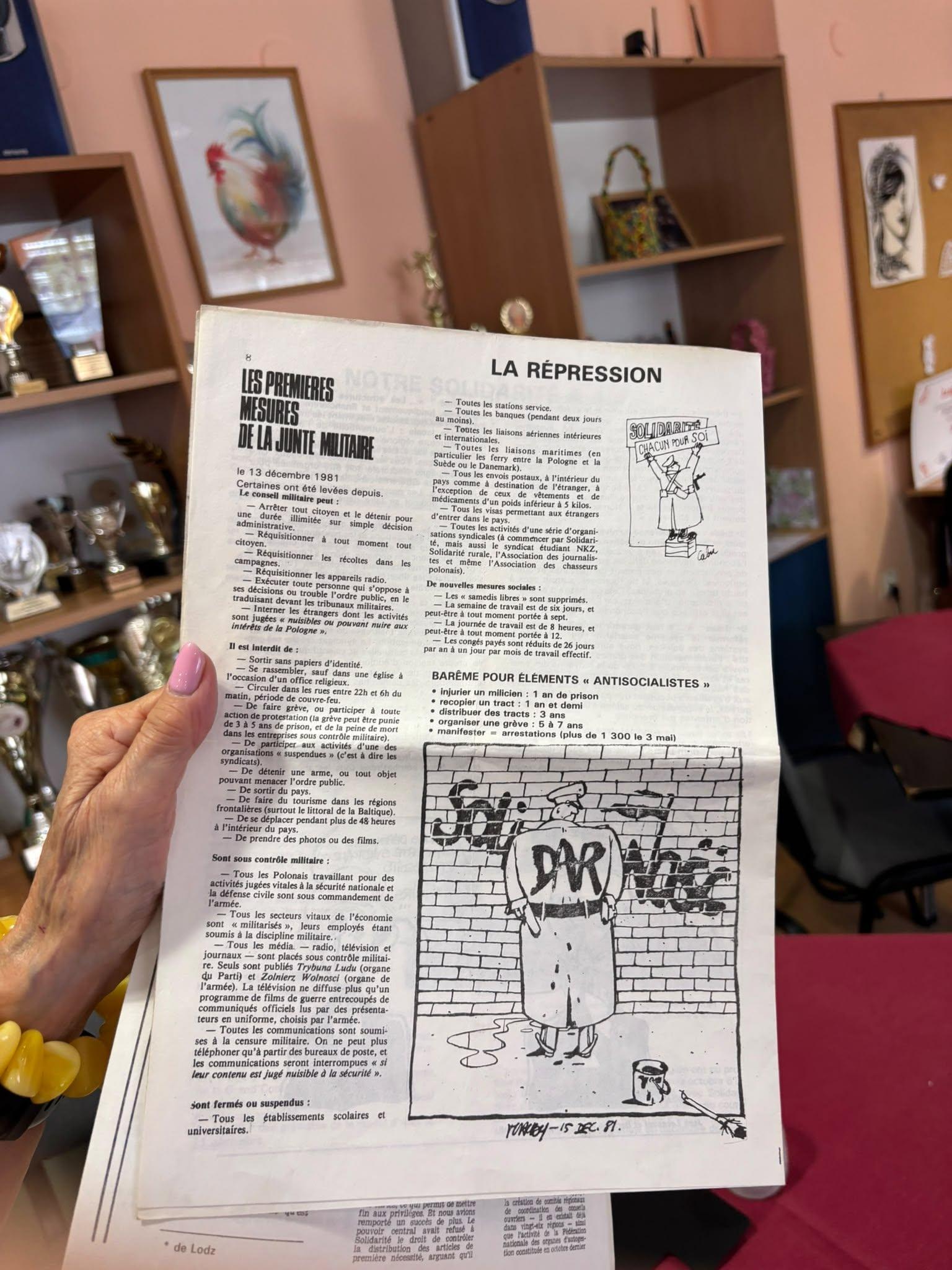 A French-language publication about martial-law repression held in a hand