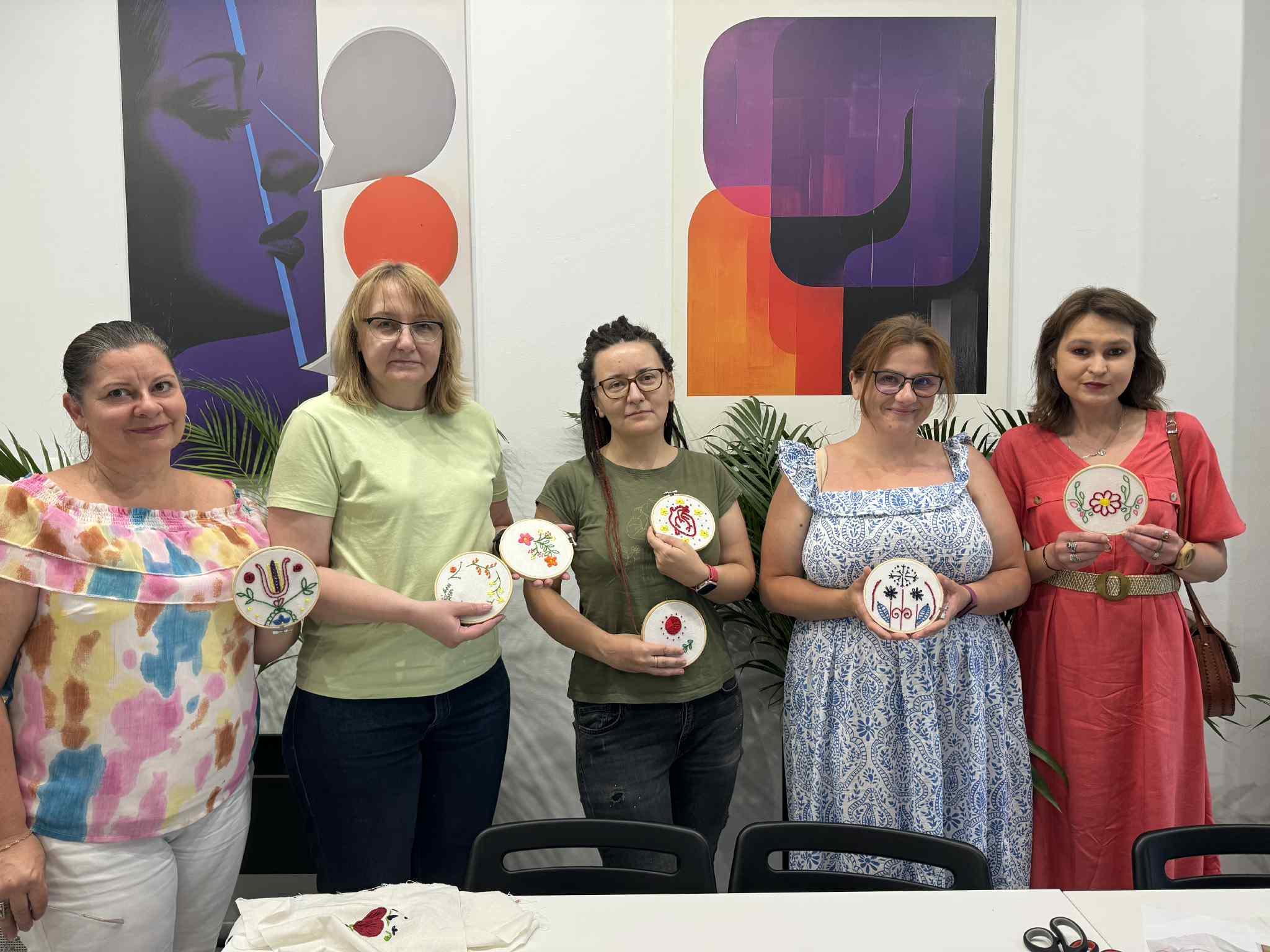 Painted tiles with floral motifs laid out on a table after an art workshop.