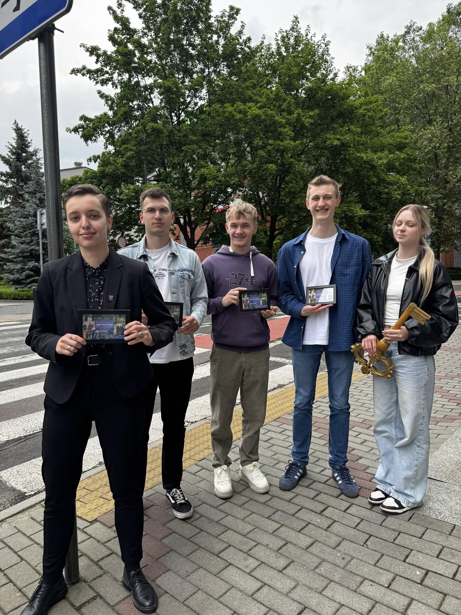 The Rybenalia team holding commemorative frames and a symbolic city key